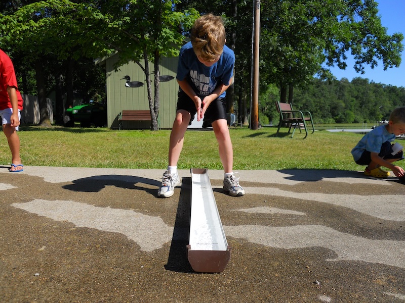 Kids racing minnows down the trough